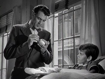 Movie still from “The Pride of the Yankees” (1942), directed by Sam Wood – An old photo of a man and a young boy; Medium shot, Low angle