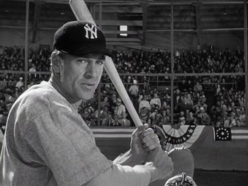 Movie still from “The Pride of the Yankees” (1942), directed by Sam Wood – A man holding a baseball bat in front of an audience; Medium shot, Low angle