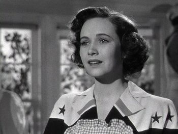 Movie still from “The Pride of the Yankees” (1942), directed by Sam Wood – A woman in a checkered apron is looking at the camera; Close Up shot, Low angle