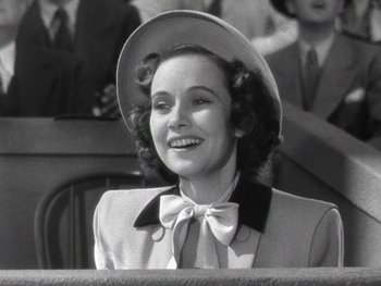 Movie still from “The Pride of the Yankees” (1942), directed by Sam Wood – An old photo of a woman in a suit and a hat; Close Up shot, Low angle