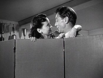 Movie still from “The Pride of the Yankees” (1942), directed by Sam Wood – A man and a woman are kissing in a room; Medium shot, Low angle