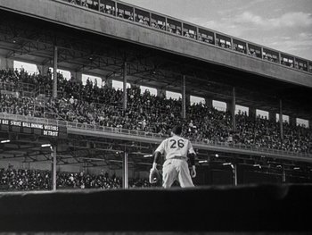 Movie still from “The Pride of the Yankees” (1942), directed by Sam Wood – A baseball player standing on top of a baseball field; Extreme Wide shot, Low angle