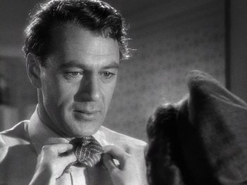 Movie still from “The Pride of the Yankees” (1942), directed by Sam Wood – A black and white photo of a man tying a tie; Close Up shot, Over the shoulder angle