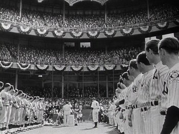 Movie still from “The Pride of the Yankees” (1942), directed by Sam Wood – A group of baseball players standing on top of a baseball field; Extreme Wide shot, High angle