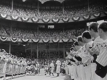 Movie still from “The Pride of the Yankees” (1942), directed by Sam Wood – A group of baseball players standing on top of a baseball field; Extreme Wide shot, High angle