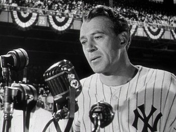 Movie still from “The Pride of the Yankees” (1942), directed by Sam Wood – A baseball player is speaking into a microphone at a baseball game; Medium shot, Low angle