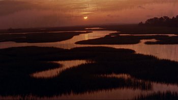 Movie still from “The Prince of Tides” (1991), directed by Barbra Streisand – The sun is setting over a body of water; Extreme Wide shot, High angle