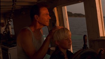 Movie still from “The Prince of Tides” (1991), directed by Barbra Streisand – A man and a boy sitting in a boat on the water; Medium shot, Low angle