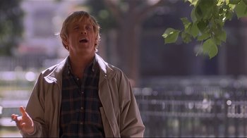 Movie still from “The Prince of Tides” (1991), directed by Barbra Streisand – A man in a plaid shirt and a tan jacket standing in front of a tree; Medium shot, Low angle