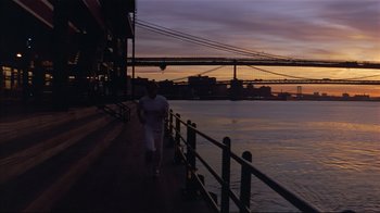 Movie still from “The Prince of Tides” (1991), directed by Barbra Streisand – A man walking along a pier near a body of water at sunset; Wide shot, Low angle