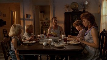 Movie still from “The Prince of Tides” (1991), directed by Barbra Streisand – A group of people sitting around a table eating food; Wide shot, Low angle