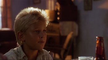 Movie still from “The Prince of Tides” (1991), directed by Barbra Streisand – A young boy sitting at a table in front of a window; Close Up shot, Low angle