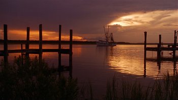 Movie still from “The Prince of Tides” (1991), directed by Barbra Streisand – A boat is in the middle of the water at sunset; Extreme Wide shot, Low angle