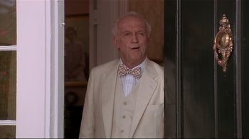 Movie still from “The Prince of Tides” (1991), directed by Barbra Streisand – An older man wearing a suit and bow tie standing in front of a door; Medium shot, Low angle