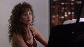 Movie still from “The Prince of Tides” (1991), directed by Barbra Streisand – A woman sitting at a piano in front of a window; Close Up shot, Over the shoulder angle