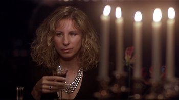 Movie still from “The Prince of Tides” (1991), directed by Barbra Streisand – A woman holding a wine glass in front of candles; Close Up shot, Over the shoulder angle
