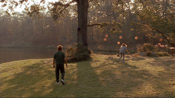 Movie still from “The Prince of Tides” (1991), directed by Barbra Streisand – Two people playing frisbee in a field near a tree; Wide shot, Over the shoulder angle