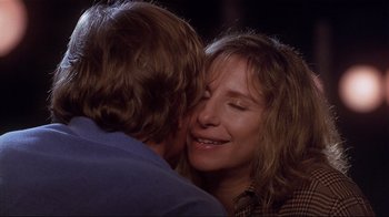 Movie still from “The Prince of Tides” (1991), directed by Barbra Streisand – A man and a woman are hugging and smiling for the camera; Close Up shot, Over the shoulder angle
