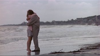 Movie still from “The Prince of Tides” (1991), directed by Barbra Streisand – A man and a woman hugging on the beach; Wide shot, High angle