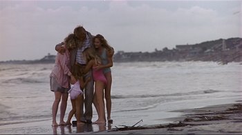 Movie still from “The Prince of Tides” (1991), directed by Barbra Streisand – A group of people standing on top of a sandy beach; Wide shot, High angle