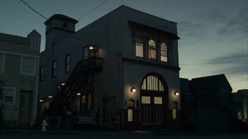 Movie still from “The Princess Diaries” (2001), directed by Garry Marshall – A building with a fire truck parked in front of it at night; Extreme Wide shot, Low angle