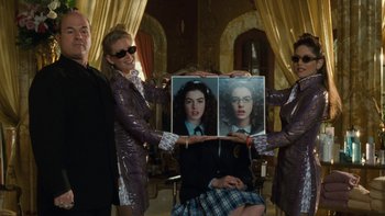 Movie still from “The Princess Diaries” (2001), directed by Garry Marshall – A group of people standing around a woman holding up a picture; Medium shot, Low angle
