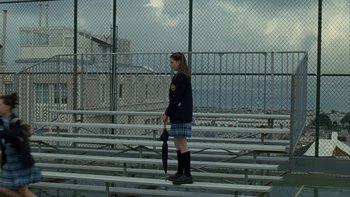Movie still from “The Princess Diaries” (2001), directed by Garry Marshall – A woman holding an umbrella while standing on a bleachers; Wide shot, High angle