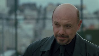 Movie still from “The Princess Diaries” (2001), directed by Garry Marshall – A man with a bald head wearing a black shirt and tie; Close Up shot, Over the shoulder angle