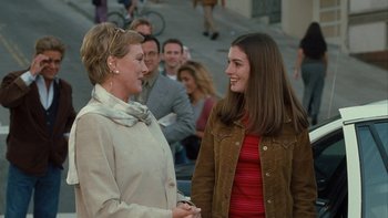 Movie still from “The Princess Diaries” (2001), directed by Garry Marshall – Two women talking to each other in front of a crowd of onlookers; Medium shot, Over the shoulder angle