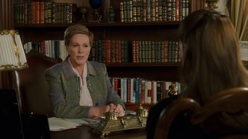 Movie still from “The Princess Diaries” (2001), directed by Garry Marshall – A woman sitting at a table in front of a book shelf; Medium shot, Over the shoulder angle