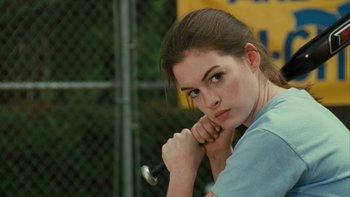 Movie still from “The Princess Diaries” (2001), directed by Garry Marshall – A woman holding a baseball bat in front of a chain link fence; Close Up shot, Over the shoulder angle