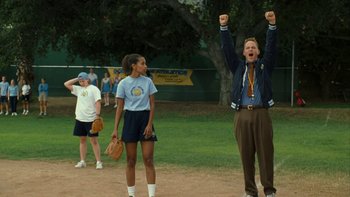 Movie still from “The Princess Diaries” (2001), directed by Garry Marshall – A man and a woman standing next to each other on a baseball field; Medium shot, Over the shoulder angle