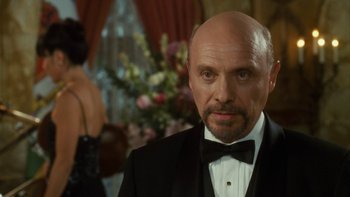 Movie still from “The Princess Diaries” (2001), directed by Garry Marshall – A bald man in a black suit and a bow tie; Close Up shot, Over the shoulder angle