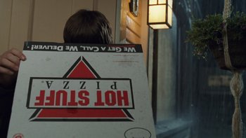 Movie still from “The Princess Diaries” (2001), directed by Garry Marshall – A man sitting in a chair with a pizza box; Extreme Close Up shot, Over the shoulder angle