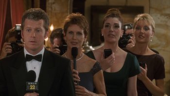 Movie still from “The Princess Diaries” (2001), directed by Garry Marshall – A group of people standing next to each other holding microphones; Medium shot, Over the shoulder angle