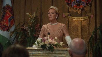 Movie still from “The Princess Diaries” (2001), directed by Garry Marshall – A woman wearing a tiara is sitting in front of a microphone; Medium shot, Over the shoulder angle