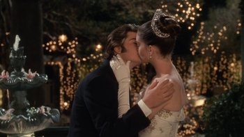 Movie still from “The Princess Diaries” (2001), directed by Garry Marshall – A man and a woman kissing in front of a string of christmas lights; Medium shot, Low angle