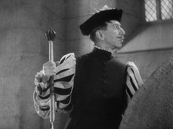 Movie still from “The Private Life of Henry VIII” (1933), directed by Alexander Korda – A man dressed in renaissance clothing holding an arrow; Medium shot, Low angle
