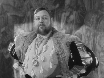 Movie still from “The Private Life of Henry VIII” (1933), directed by Alexander Korda – A man with a beard wearing a fur coat; Medium shot, Low angle