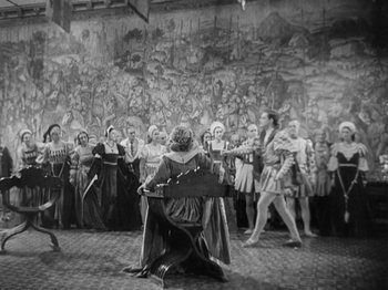 Movie still from “The Private Life of Henry VIII” (1933), directed by Alexander Korda – A group of people dressed in medieval costumes; Extreme Wide shot, High angle