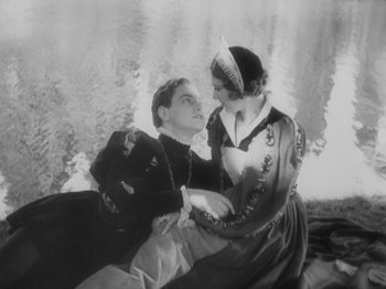 Movie still from “The Private Life of Henry VIII” (1933), directed by Alexander Korda – A man and a woman sitting next to each other on a couch; Medium shot, High angle