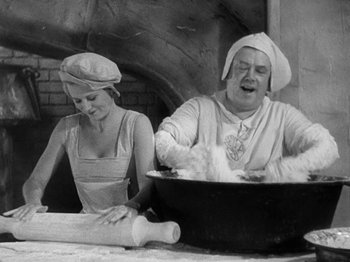 Movie still from “The Private Life of Henry VIII” (1933), directed by Alexander Korda – An old photo of a woman and a man making food; Medium shot, High angle
