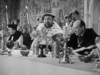 Movie still from “The Private Life of Henry VIII” (1933), directed by Alexander Korda – An old photo of people sitting at a table; Medium shot, Over the shoulder angle