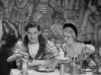 Movie still from “The Private Life of Henry VIII” (1933), directed by Alexander Korda – A man and a woman sitting at a dinner table; Medium shot, High angle