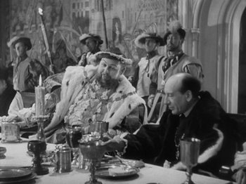 Movie still from “The Private Life of Henry VIII” (1933), directed by Alexander Korda – A group of people sitting at a table; Medium shot, Over the shoulder angle