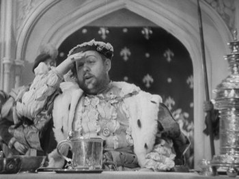 Movie still from “The Private Life of Henry VIII” (1933), directed by Alexander Korda – A man sitting at a table with his hand on his head; Close Up shot, Low angle