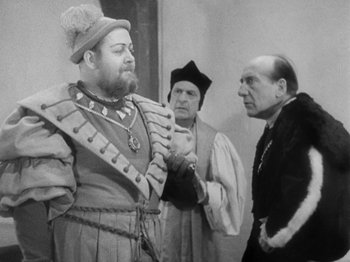 Movie still from “The Private Life of Henry VIII” (1933), directed by Alexander Korda – A group of men standing next to each other in medieval garb; Medium shot, Over the shoulder angle
