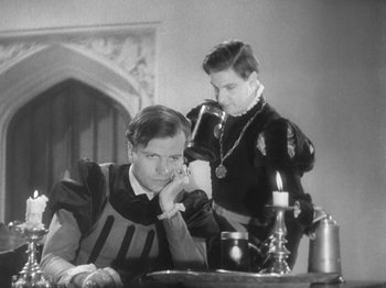 Movie still from “The Private Life of Henry VIII” (1933), directed by Alexander Korda – A man and a woman sitting at a dinner table; Medium shot, High angle