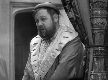 Movie still from “The Private Life of Henry VIII” (1933), directed by Alexander Korda – A man wearing a hat and a robe; Medium shot, Over the shoulder angle