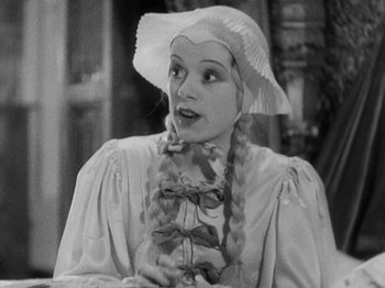 Movie still from “The Private Life of Henry VIII” (1933), directed by Alexander Korda – A woman in a white hat and a bow tie; Close Up shot, High angle
